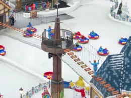 A wooden plank suspension bridge high above the indoor snow park floor