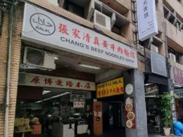 The storefront of Chang's Beef Noodles Shop along a Taipei street, showcasing a clear white signboard with Chinese characters, English text, and a circular Halal certification logo.
