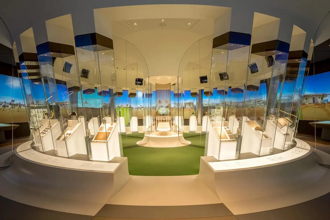 Interior of the FIFA Museum in Zurich featuring circular glass exhibits displaying historic football artifacts and memorabilia