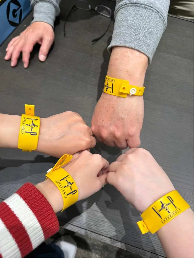 Four guests showing yellow Universal Studios Japan VIP wristbands together before entering the park for a guided afternoon experience.