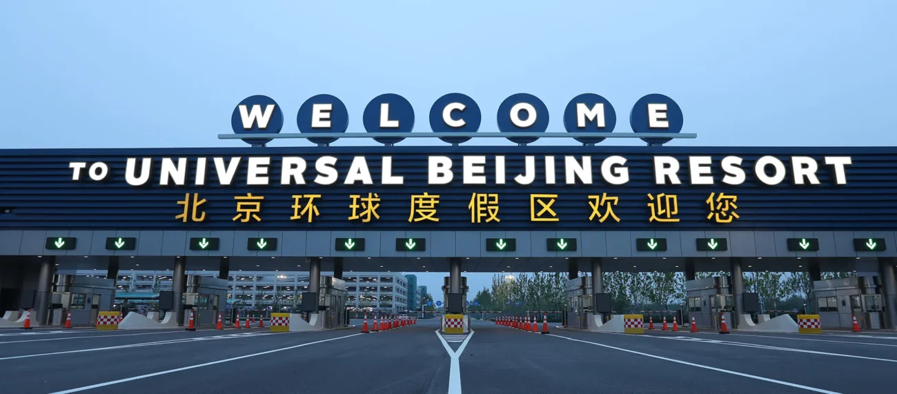 Entrance toll plaza of Universal Beijing Resort with a large lighted sign saying Welcome to Universal Beijing Resort in English and Chinese.