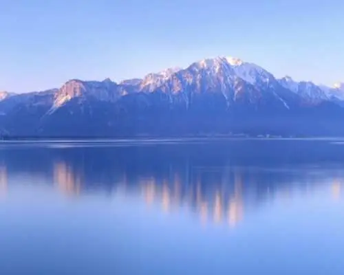 Lake Geneva calm water Alps reflection Switzerland travel guide