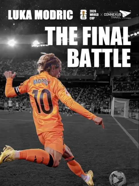 Luka Modric wearing a bright orange number 10 jersey shown from behind while kicking a football in a crowded stadium.