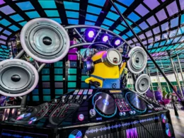 A Minion character acting as a DJ with turntables and speakers.