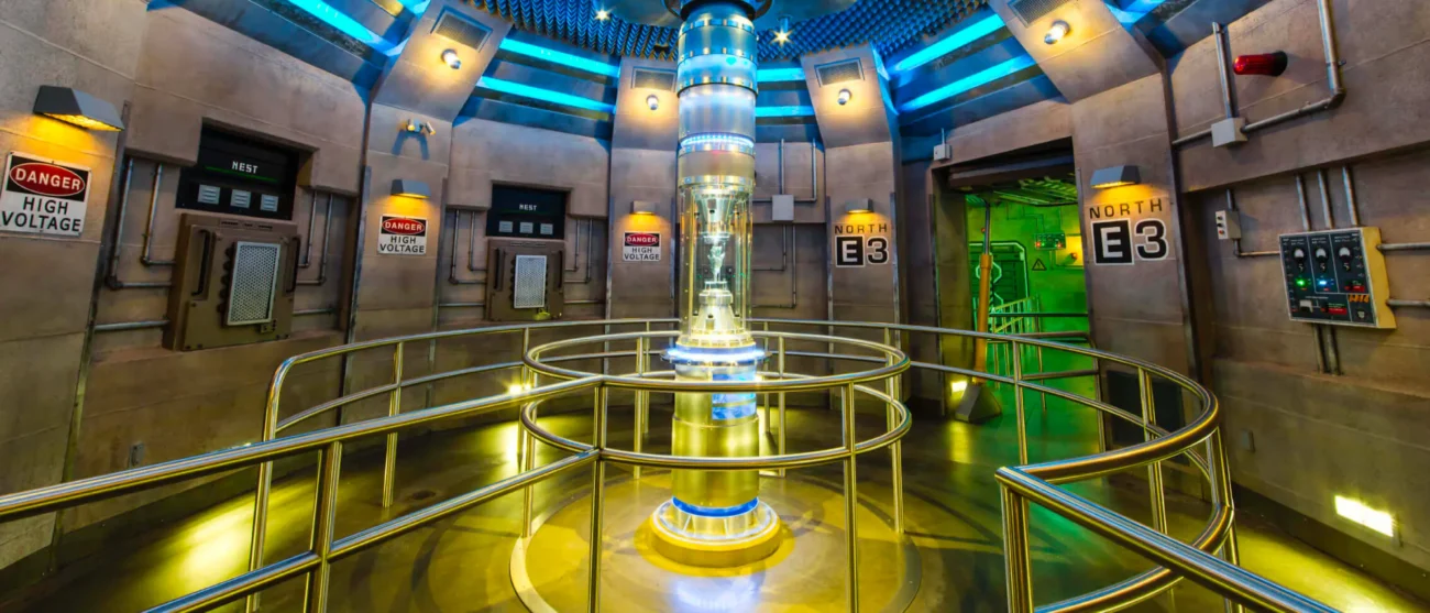 The glowing AllSpark shard contained in a high-tech glass cylinder within the metallic, industrial queue of Transformers: The Ride-3D at Universal Studios Hollywood