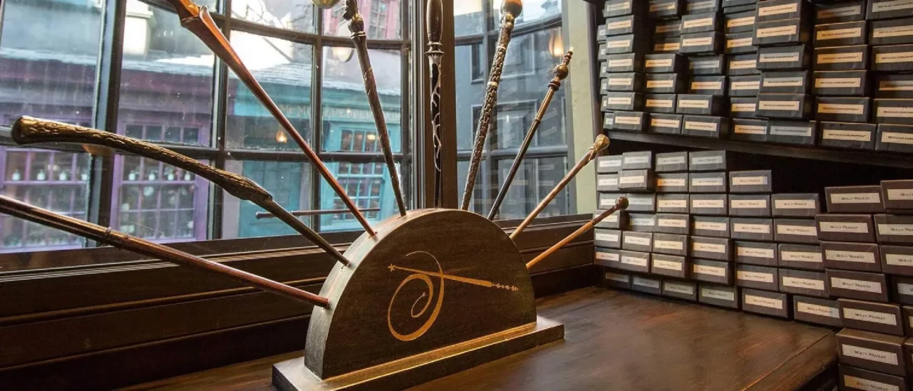 A display of various Harry Potter character wands arranged in a wooden stand inside Ollivanders wand shop at Universal Studios Hollywood