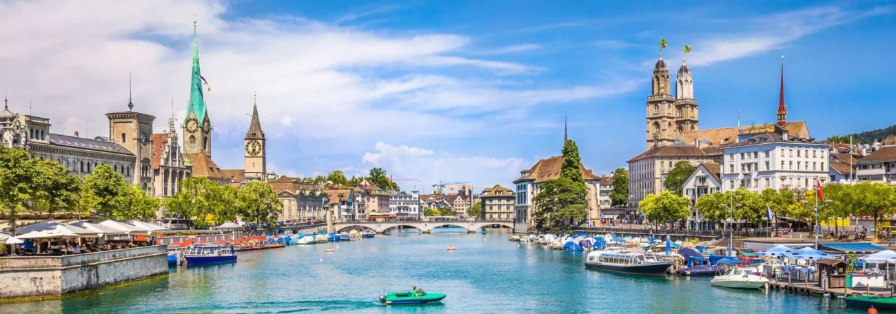 Zurich old town river skyline churches boats Switzerland travel guide